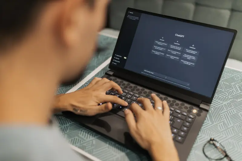 Person using AI assistant on laptop in a modern workspace